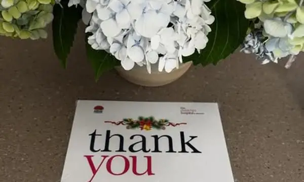 A Thank You certificate from the Children's Hospital at Westmead, beside a vase of pale blue hydrangeas, for the centre's Christmas donation to the Volunteers Service.